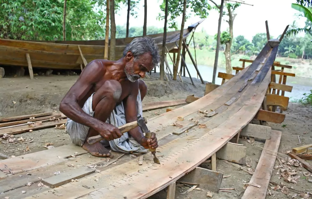 Young apprentices learning traditional woodwork joinery under master craftspeople.
